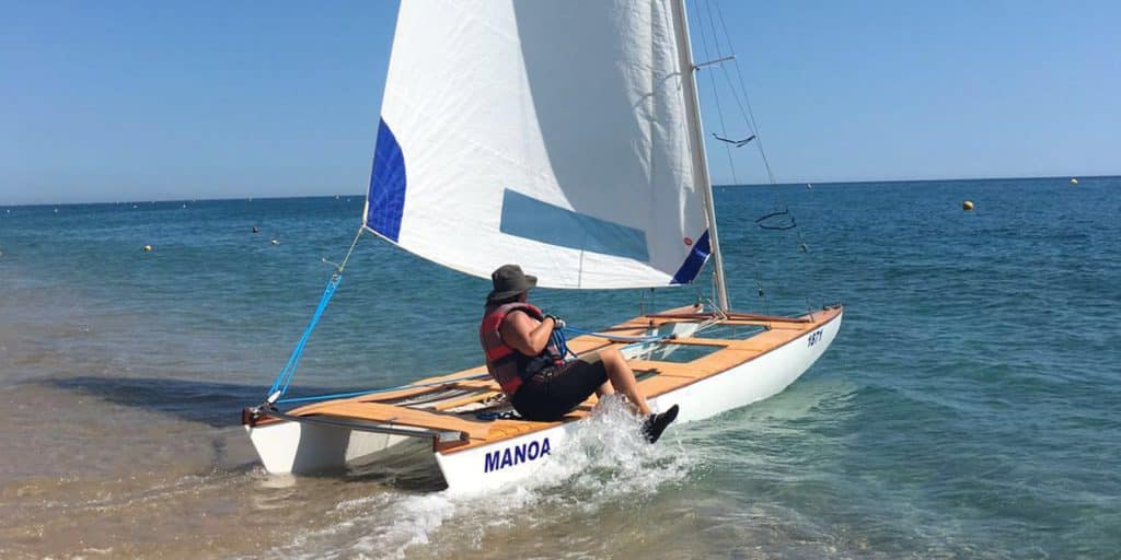 Persona navegando en velero ligero con el nombre Manoa, aplicación de SportReflex en contexto deportivo real